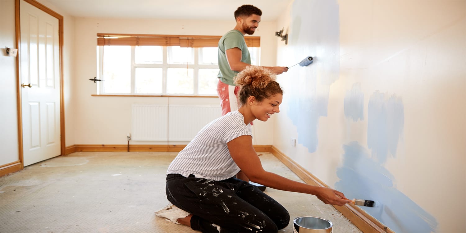 Couple painting and preparing to sell home
